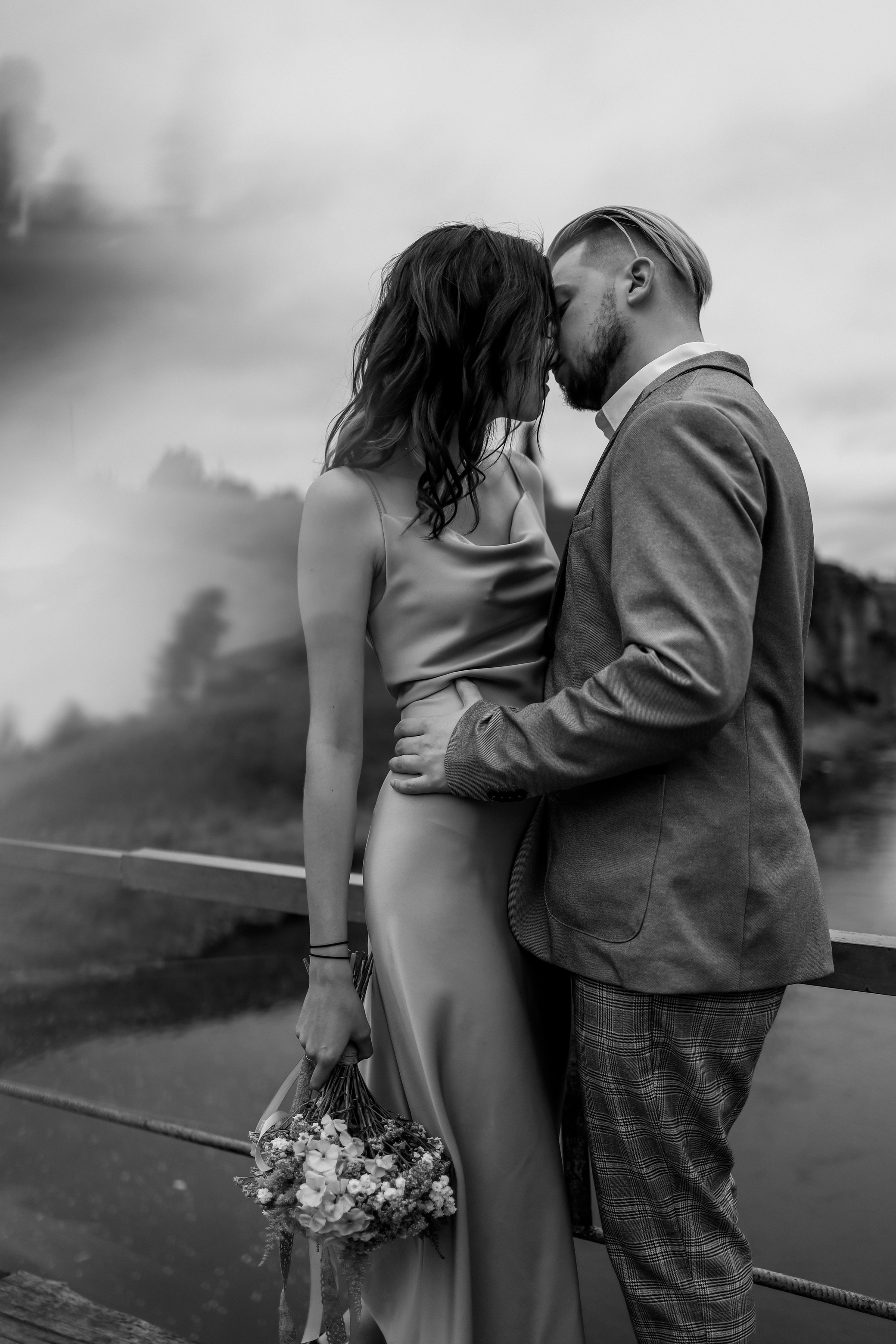 Black and white wedding photo of youn couple kissing